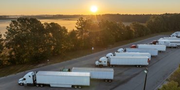 Rest area for semi trucks near busy interstate freeway. Truck stop place during hauling cargo.