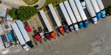 Resting place with various types of trucks in a crowded parking lot off near interstate highway